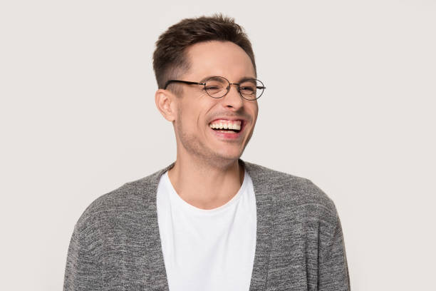 istock Happy young man laughing at funny joke squinting his eyes 1254205844