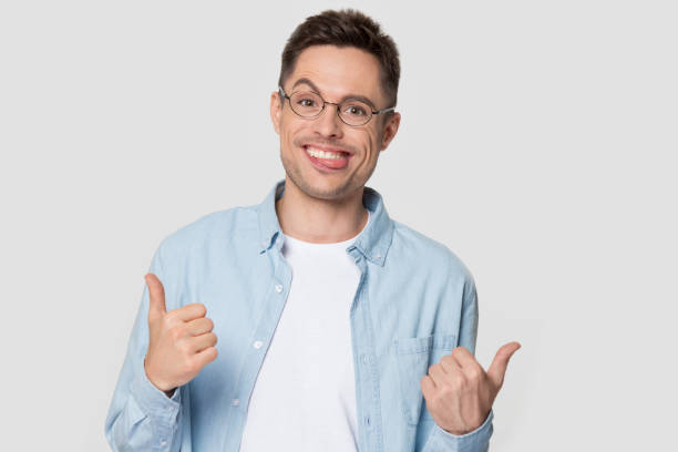 istock Young man with funny nerd jerk face showing thumb up 1254205861