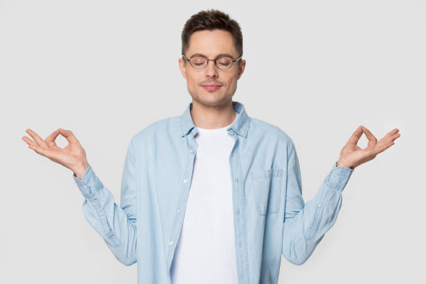 istock Relaxed millennial man standing meditating at studio with eyes closed 1254205864