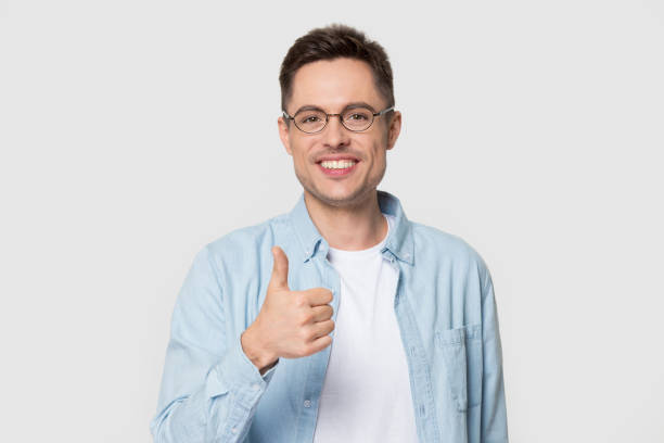 istock Head shot of smiling handsome man holding thumb up 1254205867