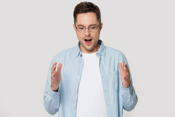 istock Surprised amazed young man demonstrates big size wide copy space. 1254205875