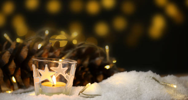 istock christmas theme with candles, snow, pine cone and christmas light 1254210409