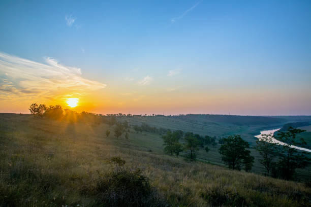 丘、畑、川の日の出。明るい空と暗い地球。夜明け。地平線上の太陽、地平線。 - sunrise hill sea sun ストックフォトと画像