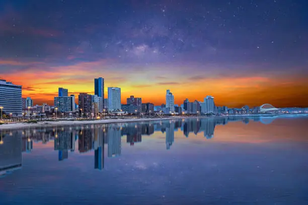 Photo of Durban city beachfront after sunset with colourful clouds and stars in the sky