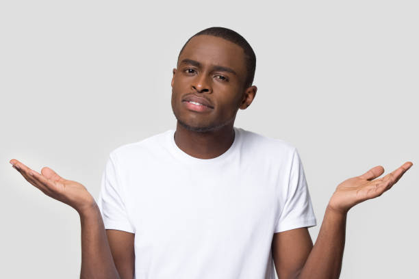 istock Confused African American man shrugging shoulders, looking at camera 1254214837