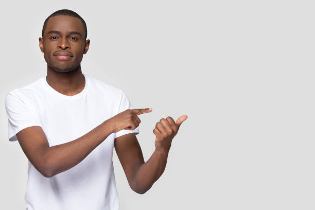 istock Handsome African American man pointing fingers aside at copy space 1254214841