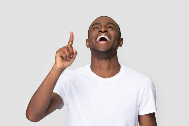 istock Excited laughing African American man pointing finger up 1254214870