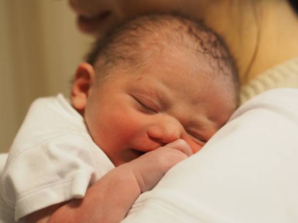 istock New Born Baby Boy Sleeping with White Baby Suit 1254216229