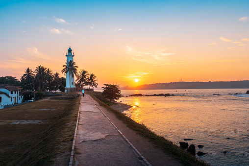 Sunrise over Galle Dutch Fort Lighthouse surrounded by coconut trees in Sri Lanka, one of the most popular travel spots in the south of the country