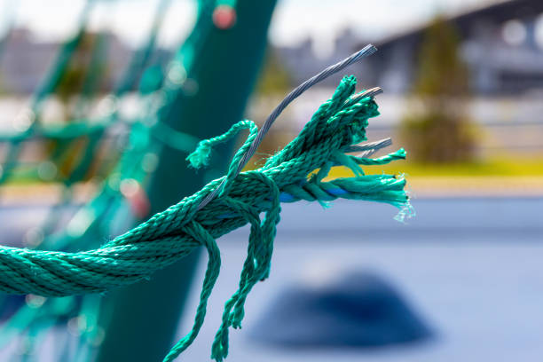 Broken climbing ropes with dangerously sticking wire in a playground. Risk of injury due to poor equipment