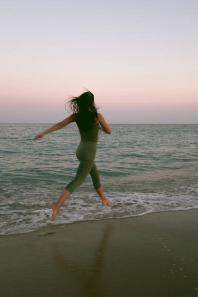 istock Young woman practicing yoga on the beach during sunset. 1254221656