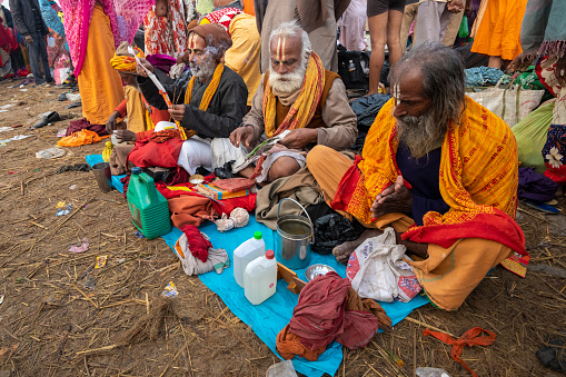 Thimphu, Bhutan - October 7: Bhutanese Monks Lunch Break Sitting On Ground Beside Dochula Passon October 7, 2022 in Thimphu, Bhutan.