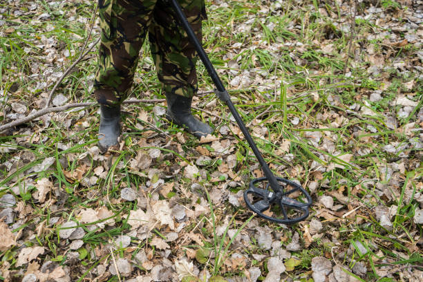 istock metal detector in the forest and a man archaeologist digging coins. 1254222696