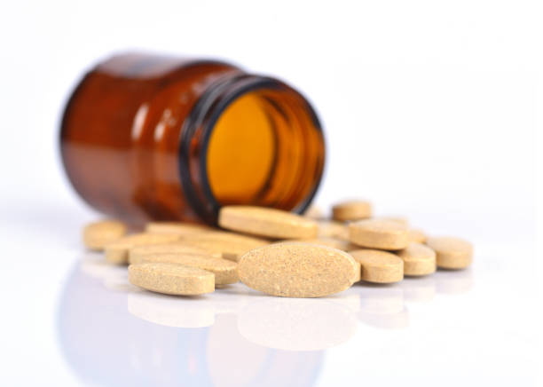 istock Two size of vitamin C bottle and pill with reflection 1254225467
