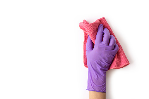 Closeup hand with gloves holding pink duster microfiber cloth for cleaning isolated on white background with clipping path.