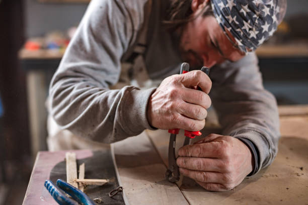 istock Male carpenter working on old wood in a retro vintage workshop. 1254229130