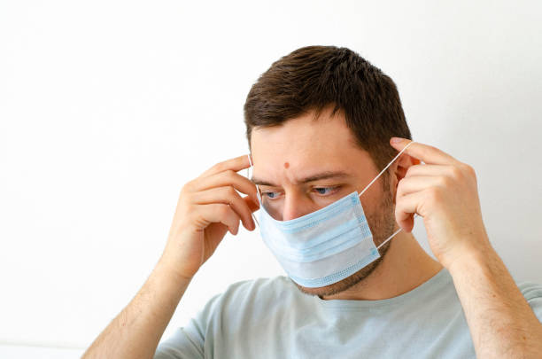 istock Coronavirus. Quarantine. A man puts on a mask. Virus protection. 1254231215