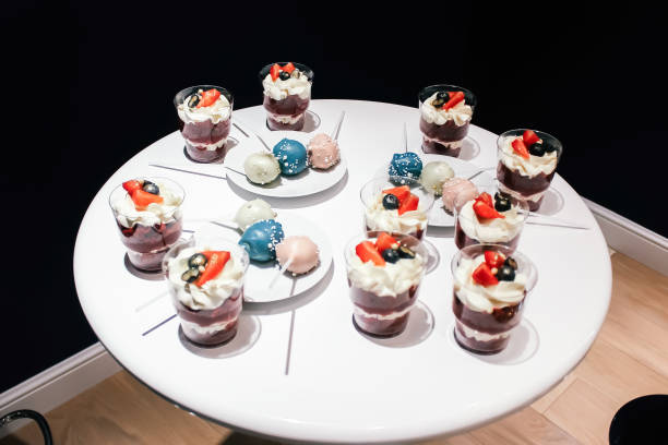istock Desserts with whipped cream and strawberries on a white table. Glamorous style 1254231503