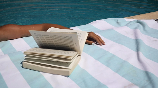 Woman Relaxing feet splashing the water in the swimming pool