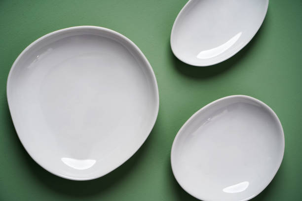 istock White vintage plates on pastel green background, top view. 1254239055