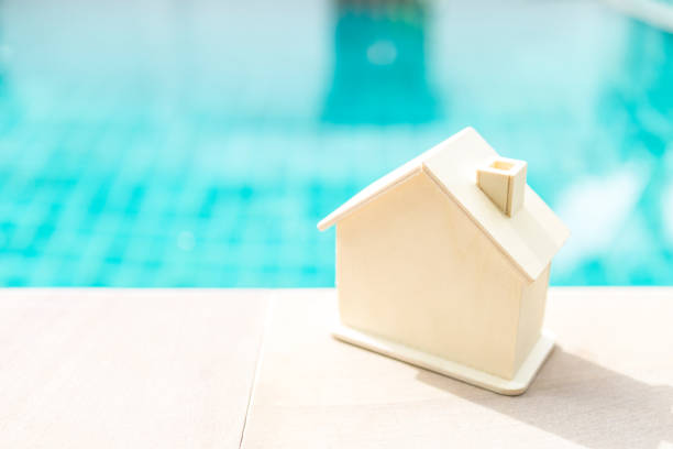 istock Wooden house over blurred swimming pool background 1254239305
