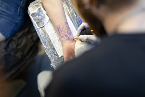 istock Tattoo artist making a tattoo on young woman’s wrist 1254241784