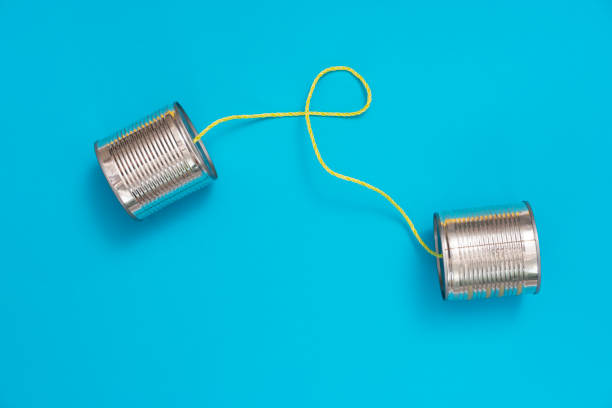 tin can phone on blue paper background - telephone can communication tin can phone imagens e fotografias de stock