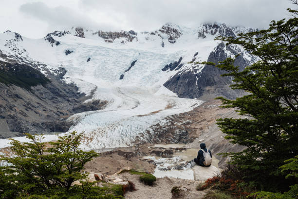 istock Alone man sitting on the stone and looking at the Glacier Torre 1254245462