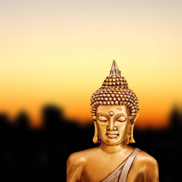 istock Bronze Zen Buddha Statue on golden sunset background. 1254250178