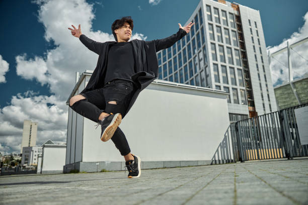 istock Handsome guy in black outfit doing tricks on the street 1254250589