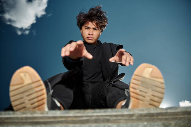 istock Stylish young man standing under blue cloudy sky 1254250617