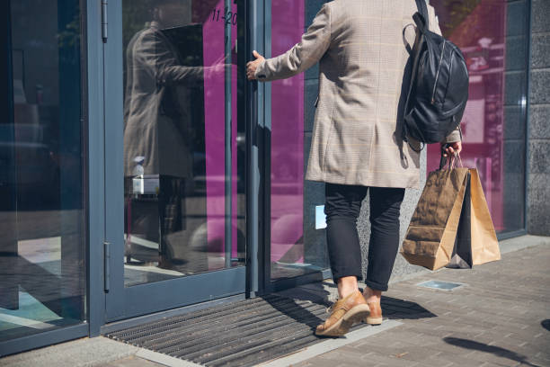 istock Stylish young man walking into the store 1254250643