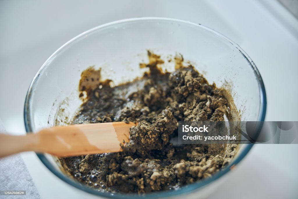 Espátula de madera en cuenco de vidrio con arcilla y sustancia herbosa - Foto de stock de Antiarrugas libre de derechos Espátula de madera en cuenco de vidrio con arcilla y sustancia herbosa - Foto de stock de Antiarrugas libre de derechos