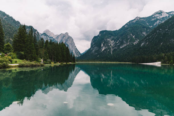 istock Wide lake between mountains covered with forest 1254253857