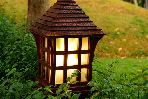 Vintage lamp on street with wood in garden