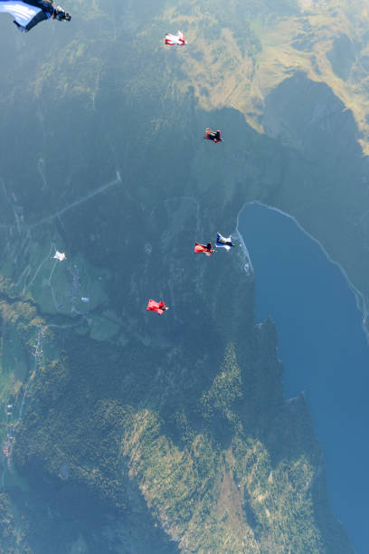 istock Wing suit fliers glide through clear skies 1254261948