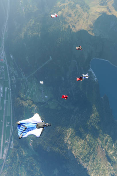 istock Wing suit fliers glide through clear skies 1254261950