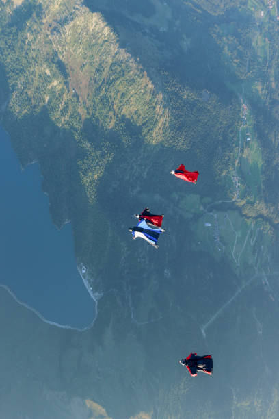 istock Wing suit fliers glide through clear skies 1254262617