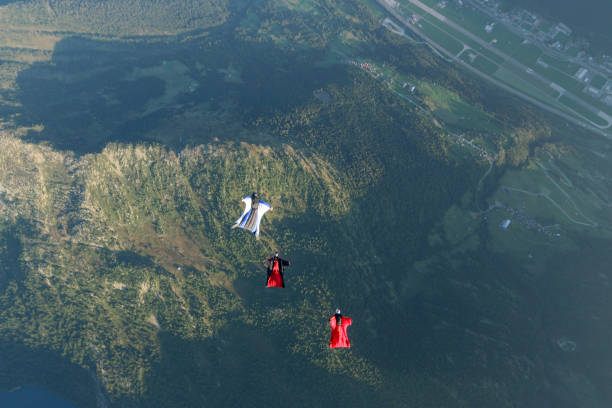 istock Wing suit fliers glide through clear skies 1254262966