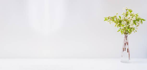 istock Home interior with decor elements. Spring flowers in a vases on a light background 1254263107