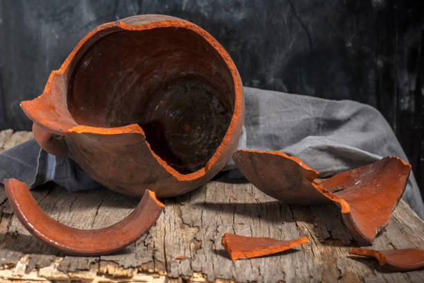 сломанный глиняный кувшин на деревянном столе - jug decorative urn ancient greek culture стоковые фото и изображения