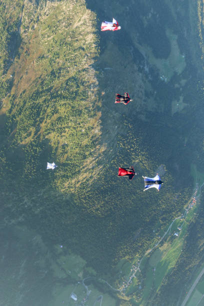 istock Wing suit fliers glide through clear skies 1254263811