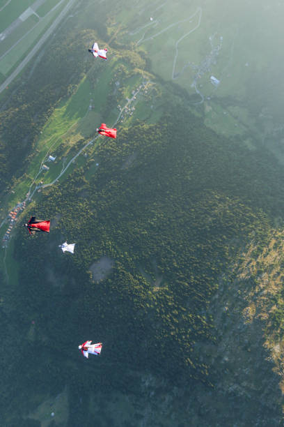 istock Wing suit fliers glide through clear skies 1254263917