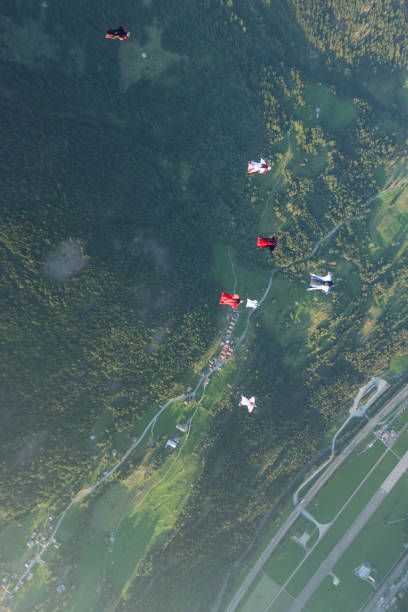 istock Wing suit fliers glide through clear skies 1254264180