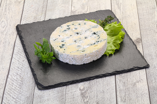 Round blue cheese with salad and basil