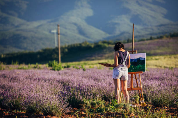 istock Female painter painting on lavender field 1254268316