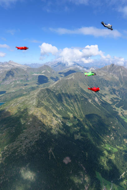 istock Wing suit fliers glide through clear skies 1254268318