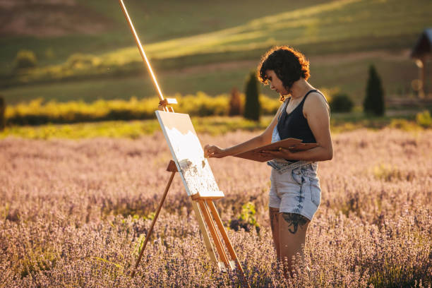 istock Female painter painting on lavender field 1254268665