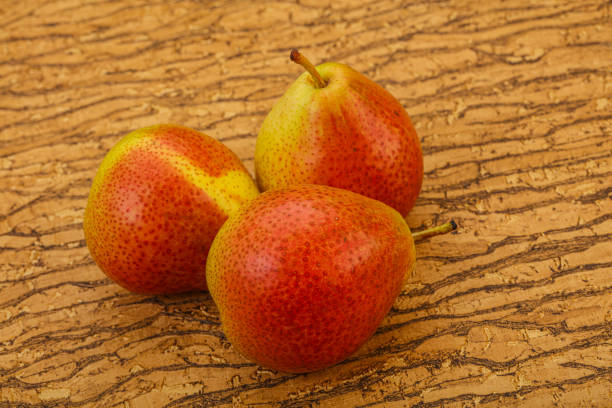 Close-up of ripe pears on a green grass background in the orchard garden. Shallow depth of field.