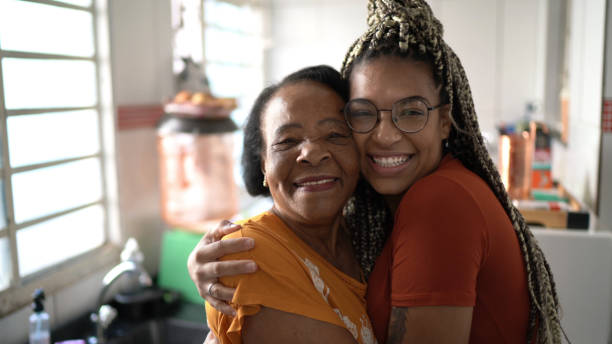 Portrait of grandmother and granddaughter embracing at home Portrait of grandmother and granddaughter embracing at home i love you photos stock pictures, royalty-free photos & images